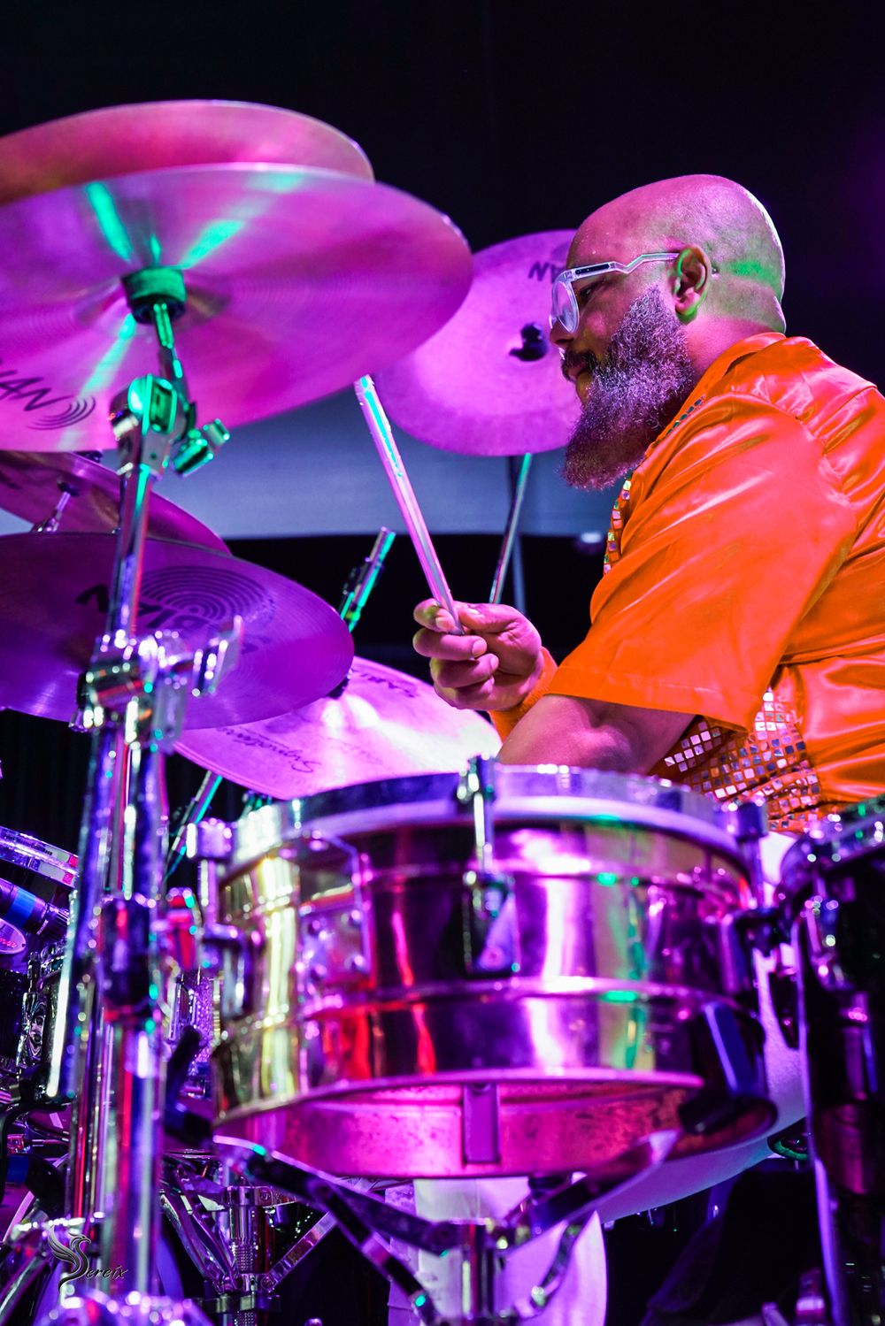 Musician performing live on stage under colorful concert lights, high-energy live music event photography by SRX Media Group
