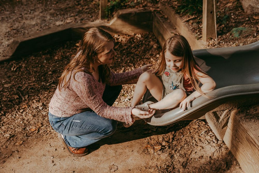 Mom and daughter playing on a slide in a forest. Whitney Popp, Phoenix AZ photographer.
