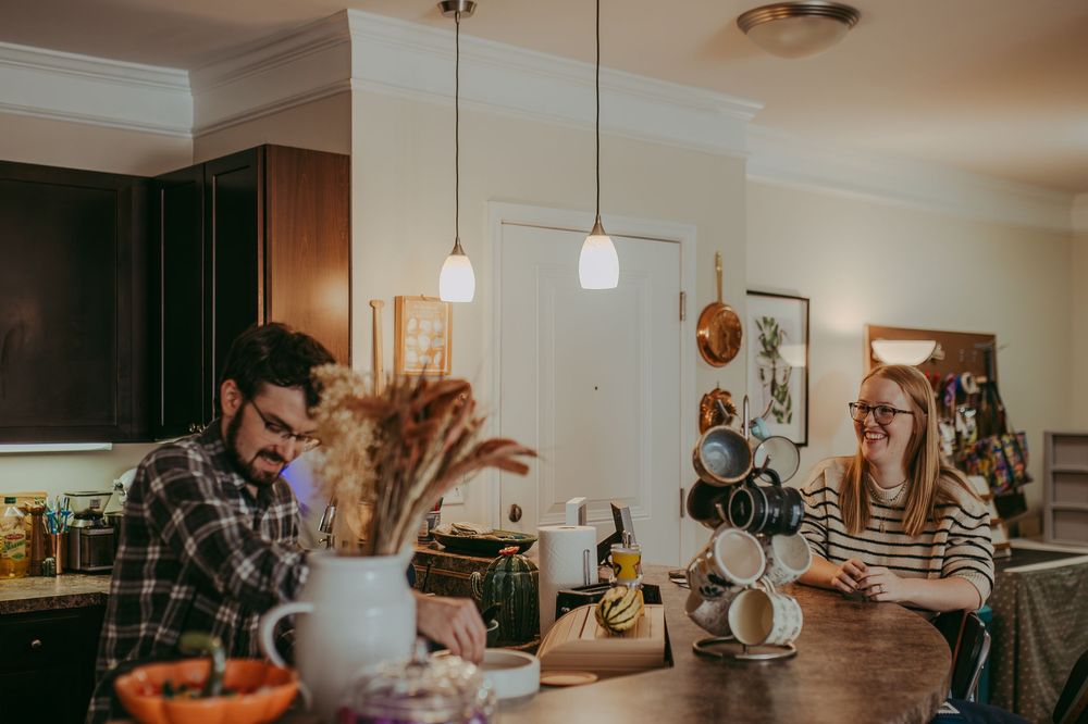 A husband and wife enjoy a moment at the counter in a kitchen with warm lighting. Whitney Popp, Phoenix AZ photographer.