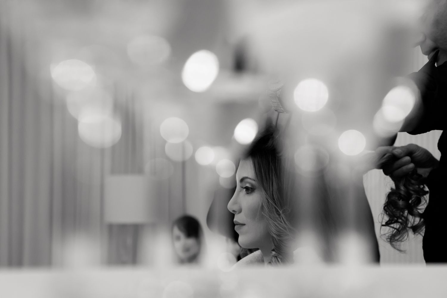 Artistic black and white profile shot with soft bokeh lights in background.