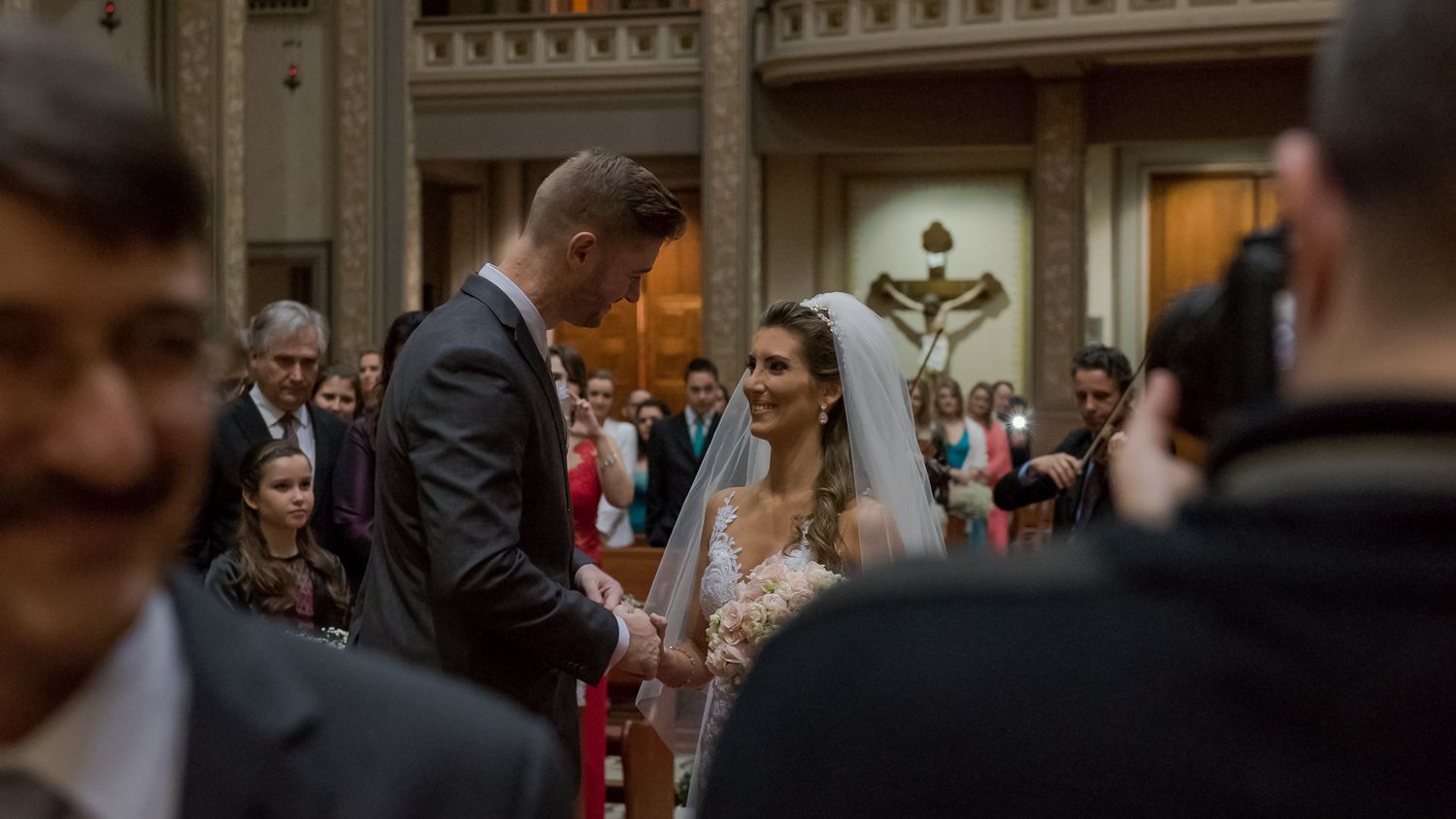 Traditional wedding ceremony taking place in an ornate church setting.