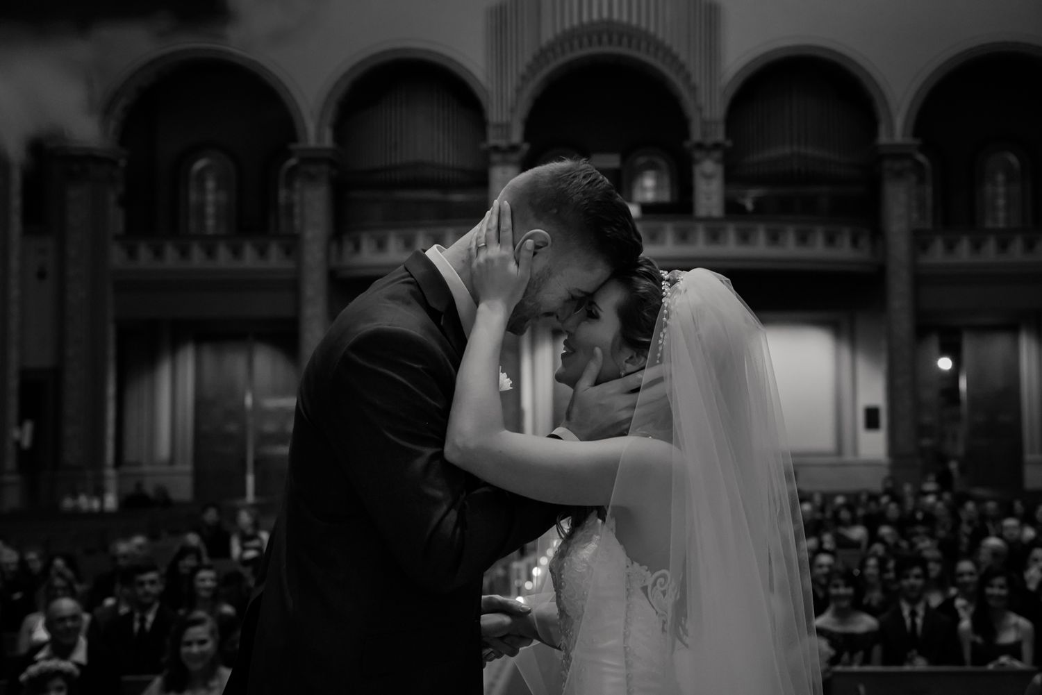 Black and white capture of an intimate moment during a church wedding ceremony.