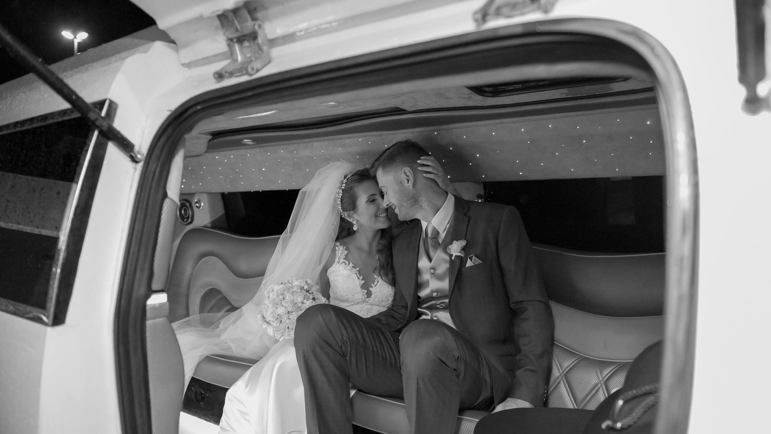 Intimate moment captured in black and white inside a vintage vehicle.