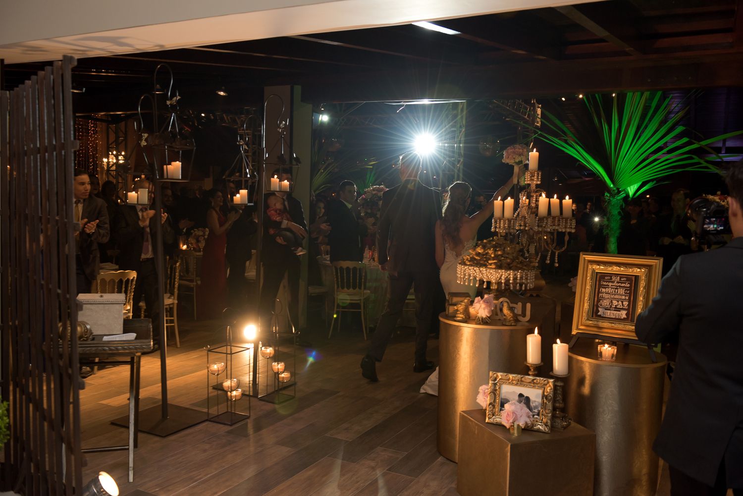 A dimly lit wedding reception venue with decorative lights and elegant table settings.