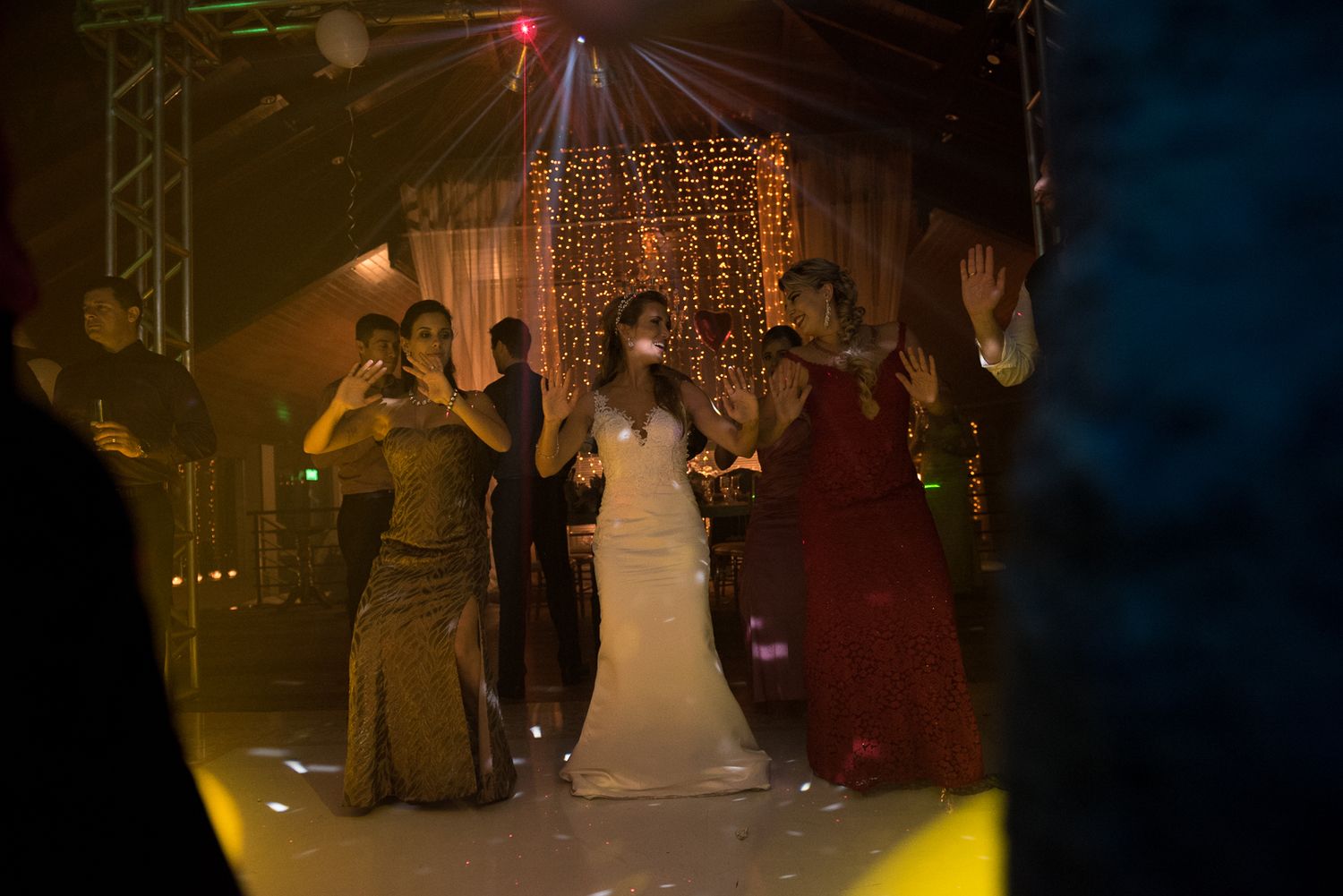 Wedding party members dancing together under dramatic lighting and disco balls.