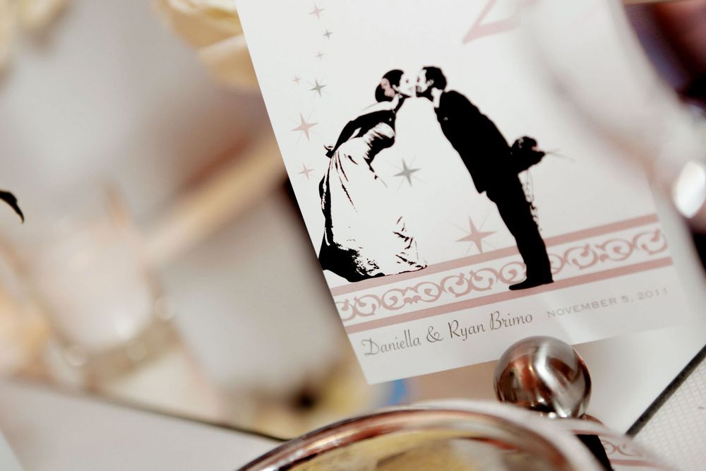 A vintage-style silhouette illustration of a couple kissing on a wedding invitation or card.