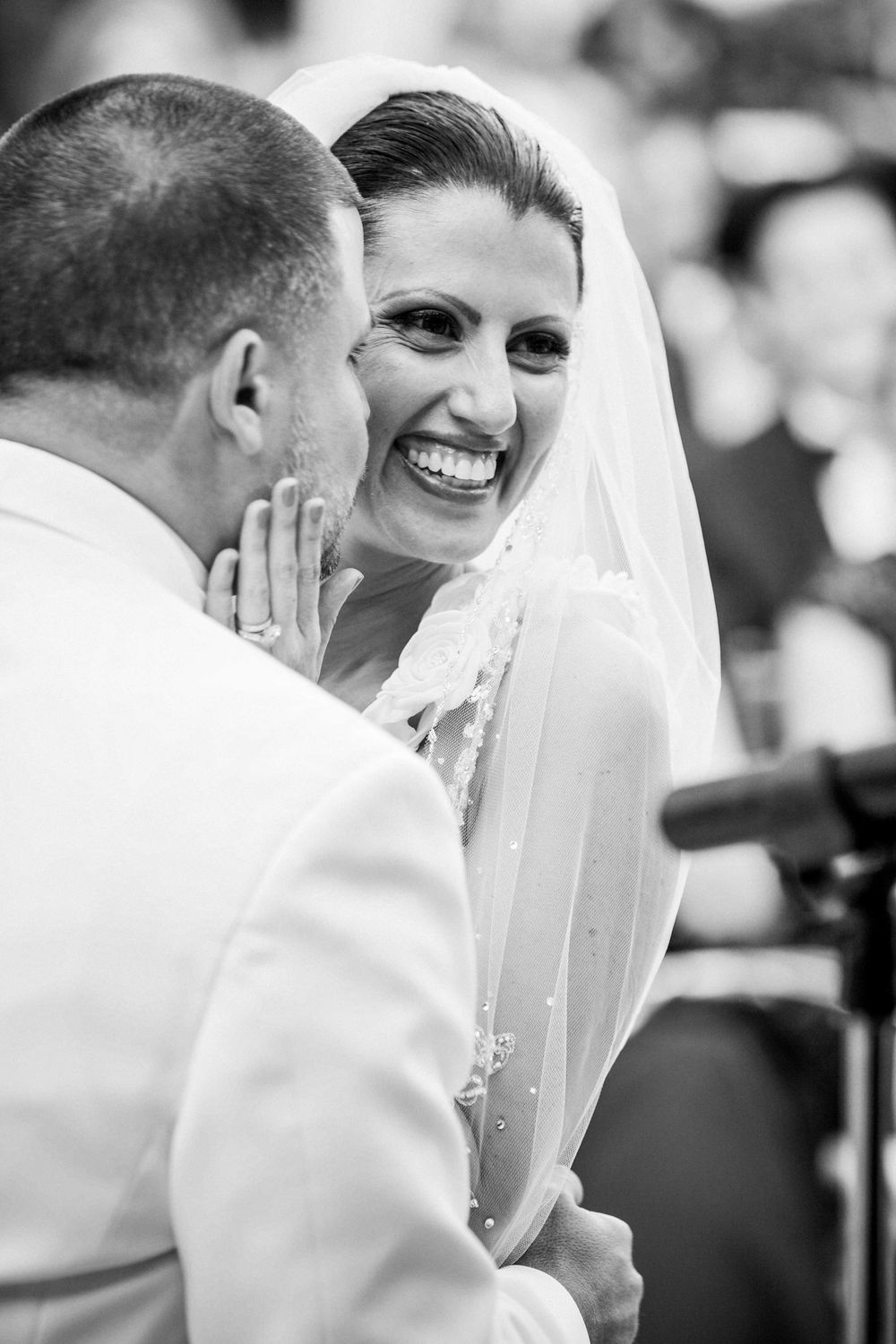 A joyful moment captured between newlyweds during their wedding ceremony in black and white.