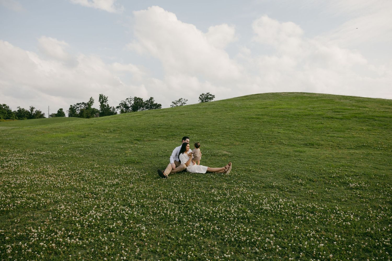 A picnic blanket set up on a scenic hilltop with golden grass and mountains in the background.