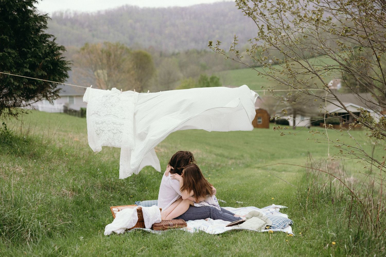 White fabric flowing in the breeze across a green hillside landscape. Separk Mansion Wedding Photographer
