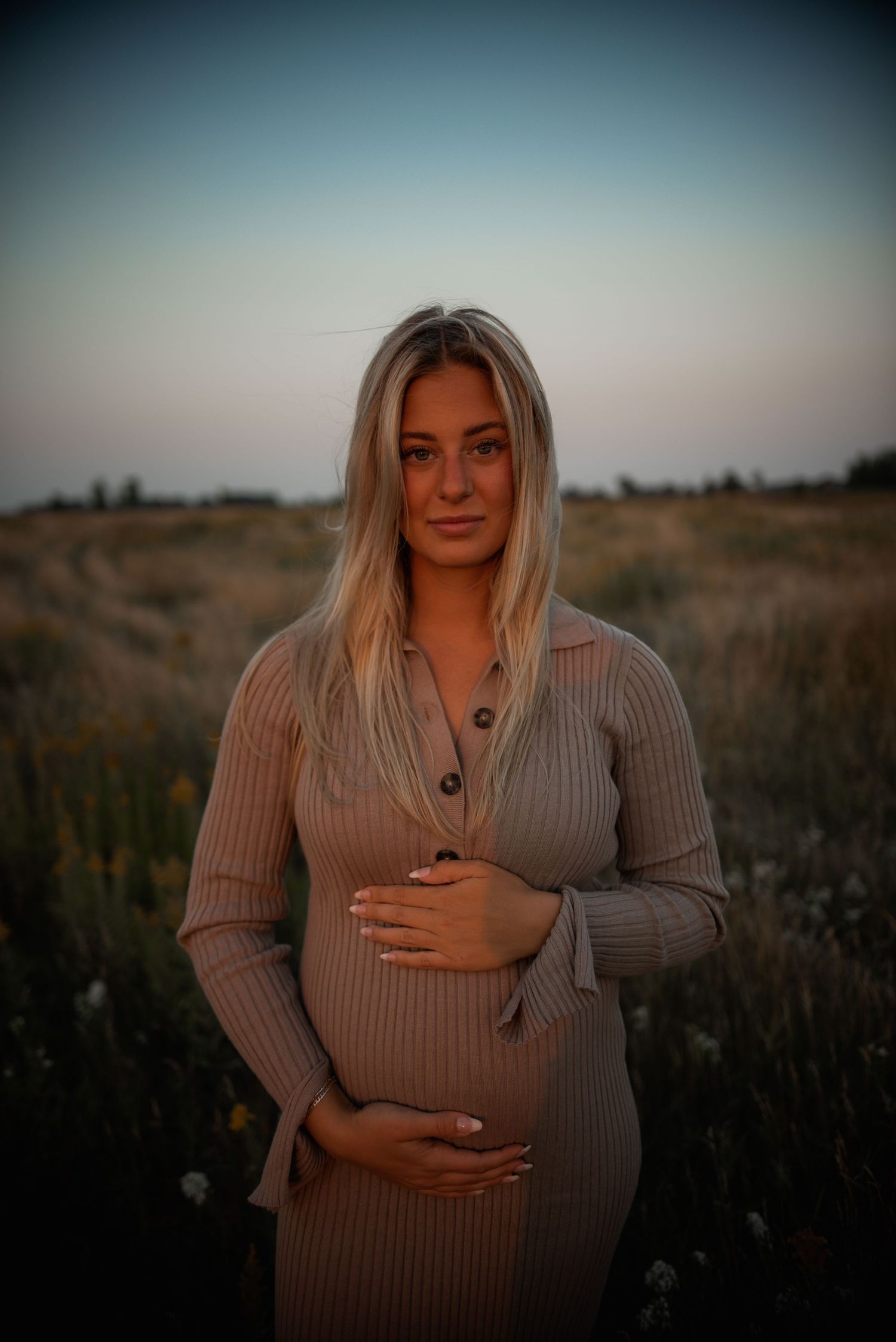 A series of maternity photos showing a person in a beige sweater cradling their baby bump in a natural outdoor setting.