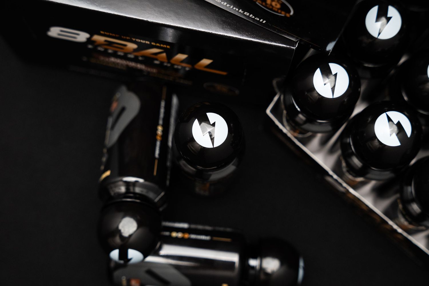 Black and silver e-cigarette batteries and parts photographed with dramatic lighting on dark background.