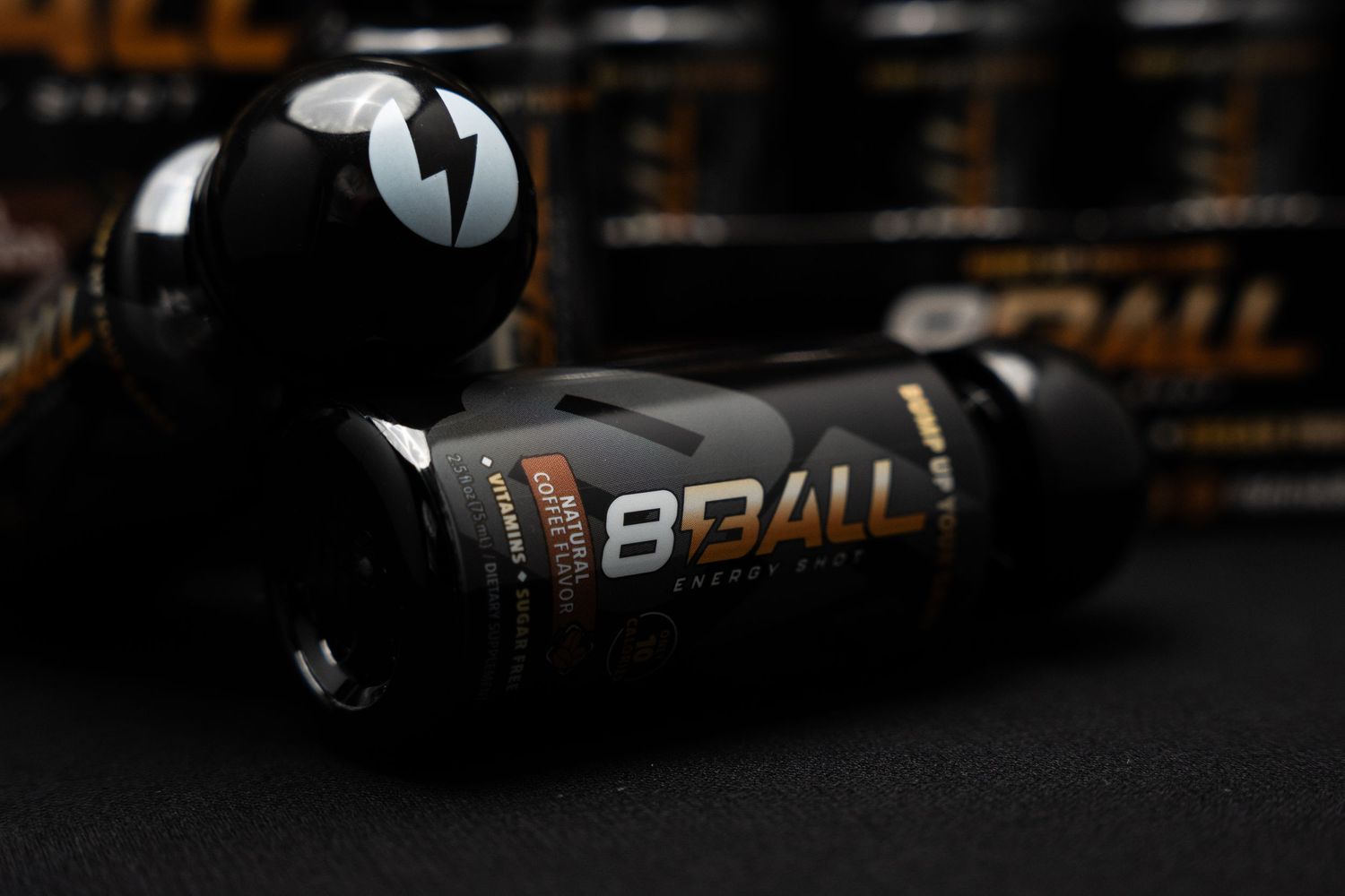 Black 8 Ball branded sports drink bottles displayed against dark background with selective focus.