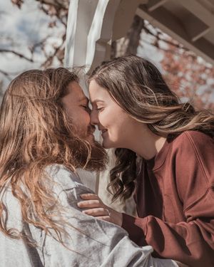 A romantic couple in brown and white clothing share tender moments in a series of intimate poses.