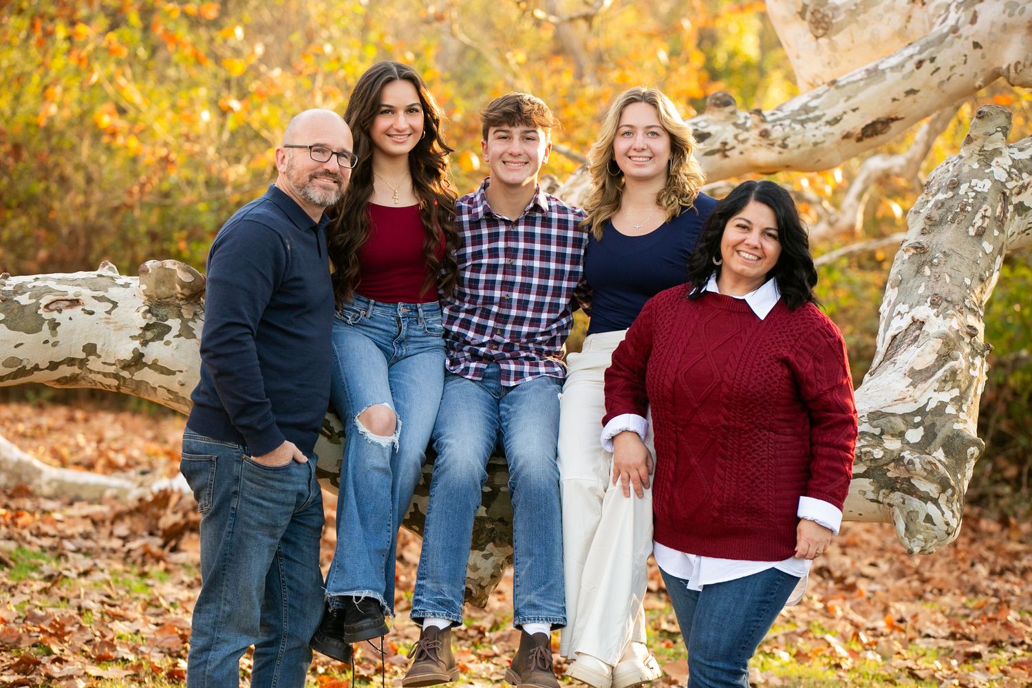 Extended family group photos in autumn setting with fall foliage backdrop.
