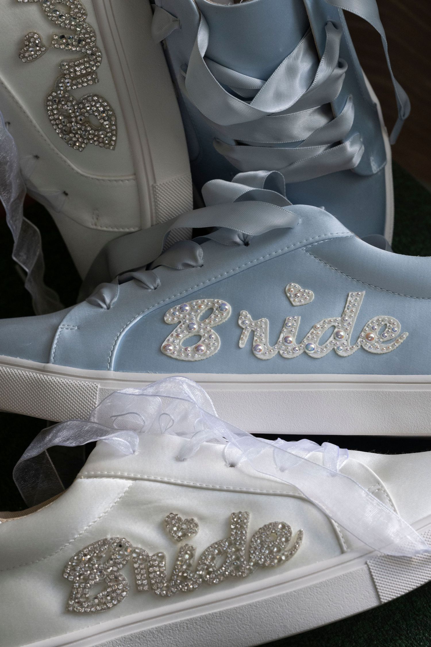 White and blue wedding sneakers with rhinestone 'Bride' text decoration displayed together.