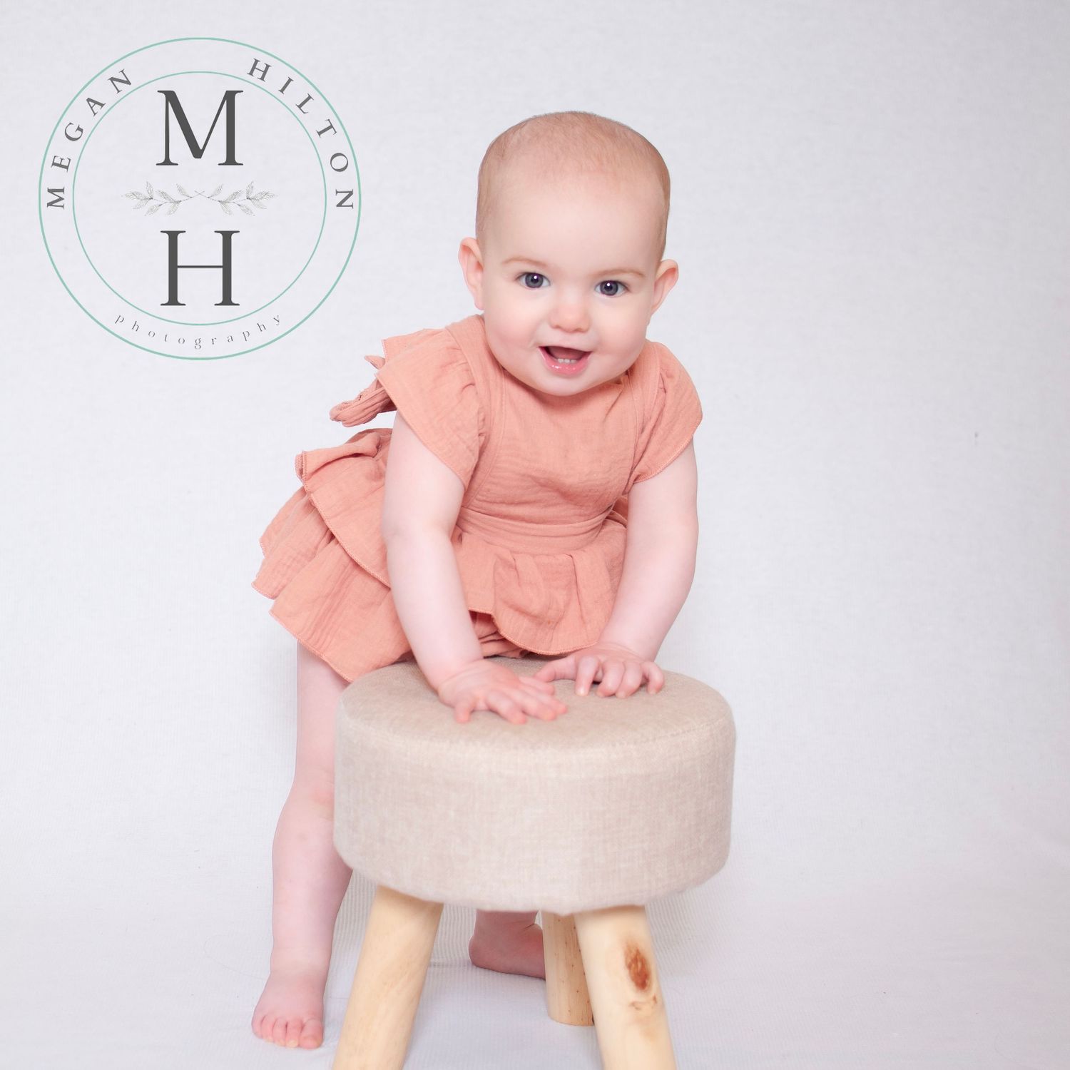 One year old girl standing with stool photo