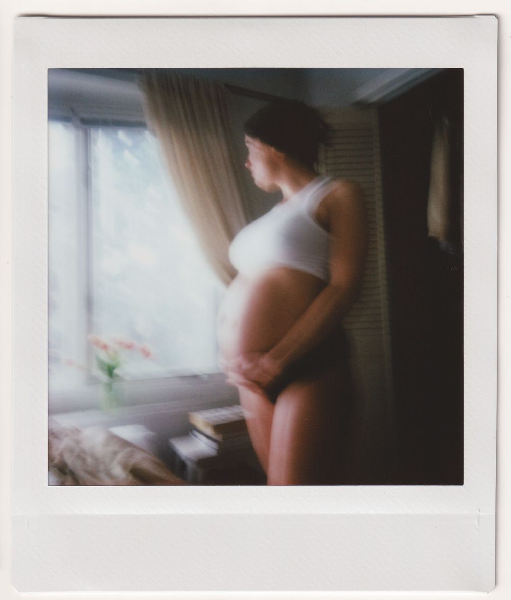 Soft focus vintage Polaroid photograph captured in a sunlit bedroom with curtains.