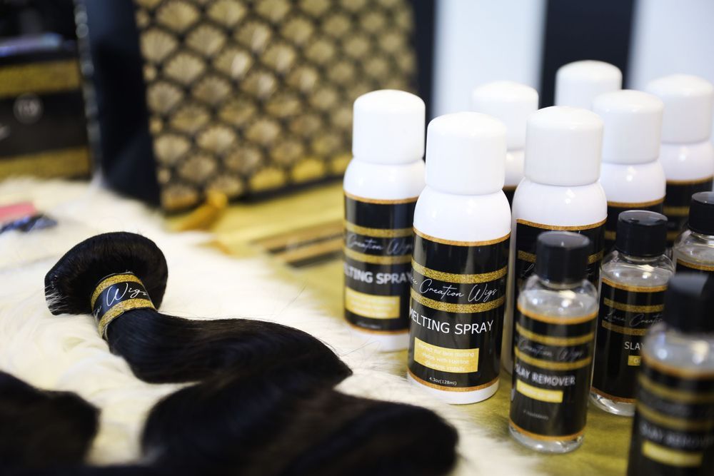 Bottles of beauty or hair care products arranged with black accessories on a white surface.