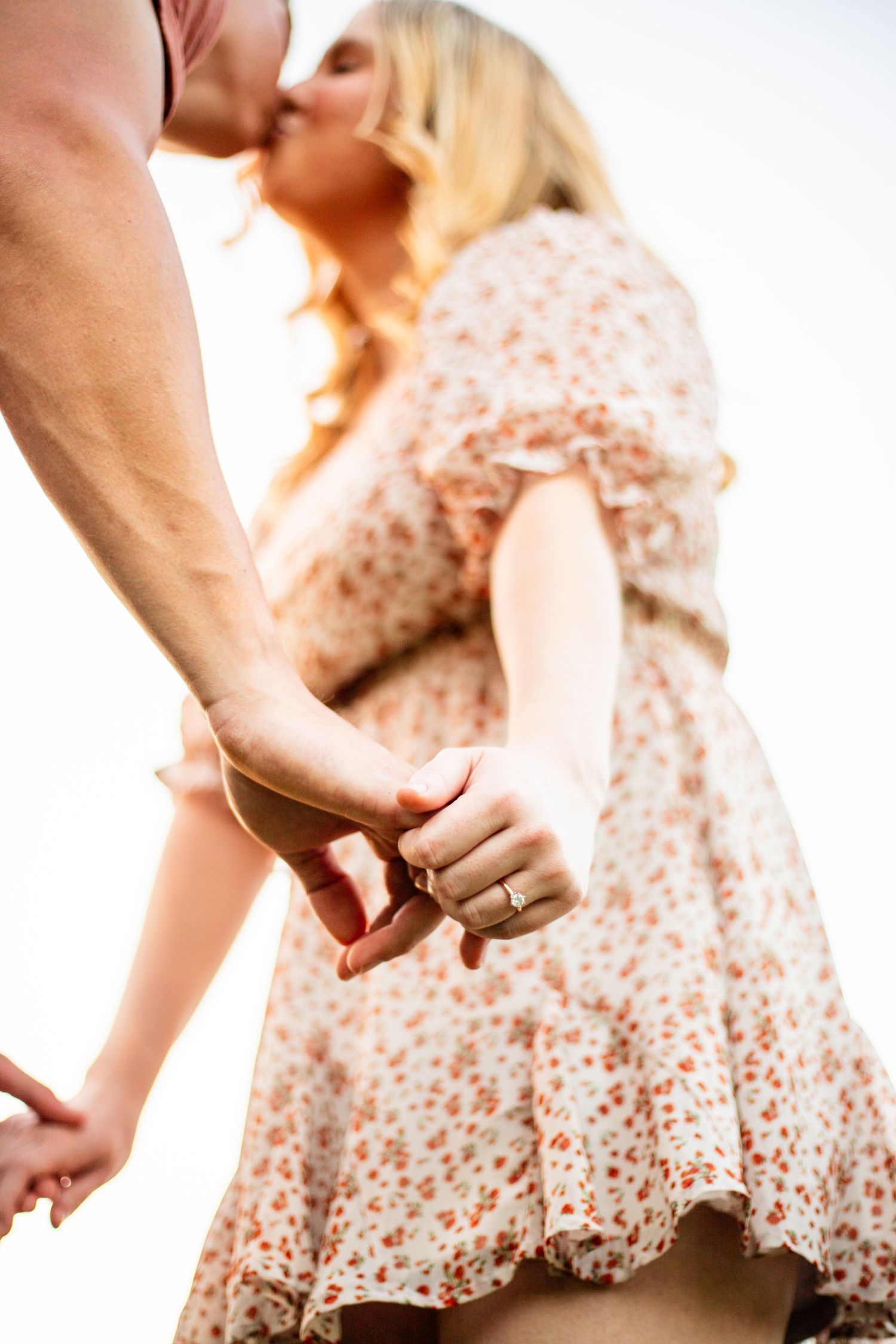 Couple holding hands with woman wearing floral dress in soft focus romantic setting. Geneva, Florida