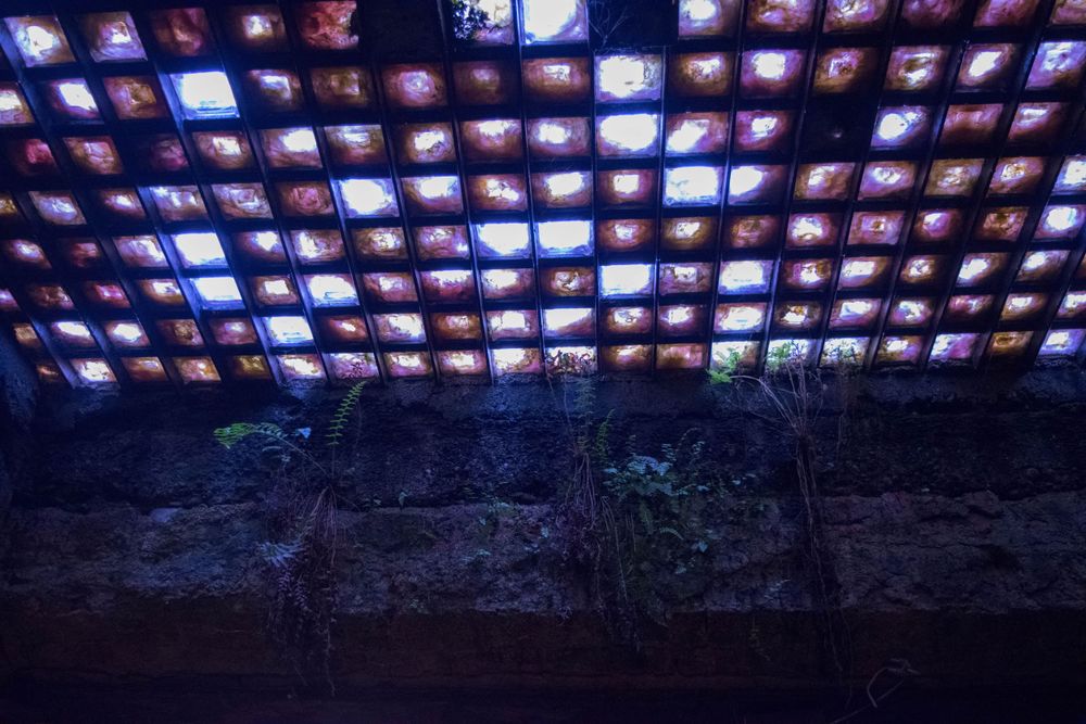 Illuminated grid of blue and purple lights creating a pattern in a dark space.