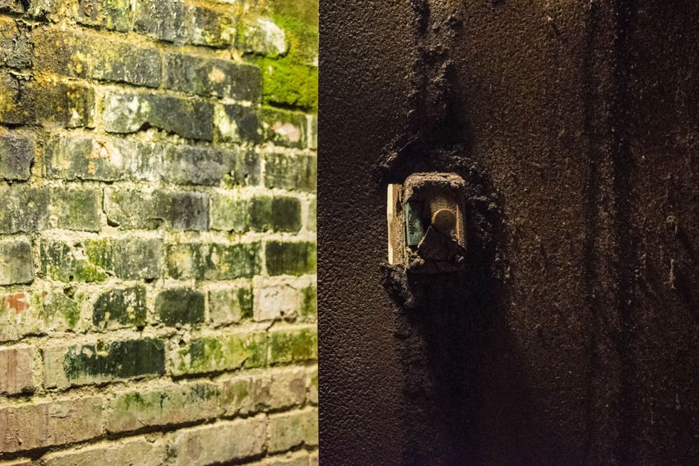 Old rusty keyhole on weathered brick wall with moss growth.
