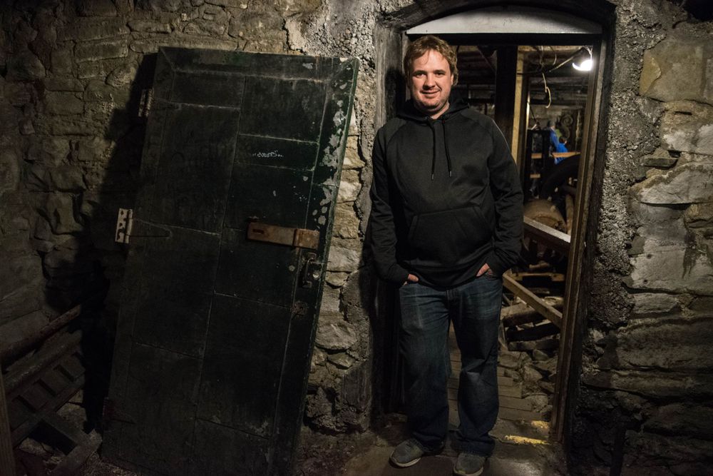 Dark doorway in old stone basement with vintage metal door.
