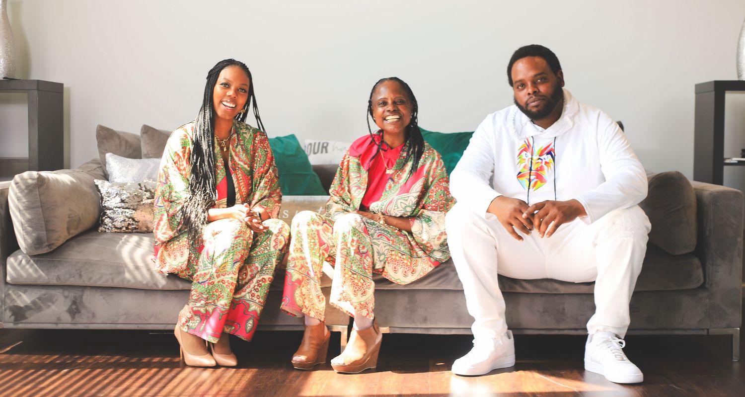 Portrait of a family of 3 sitting on a couch.