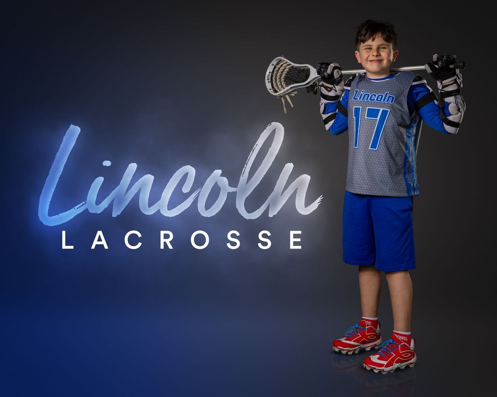 Young lacrosse player in Lincoln #17 blue jersey holding stick, posing for Lincoln Lacrosse team photo.