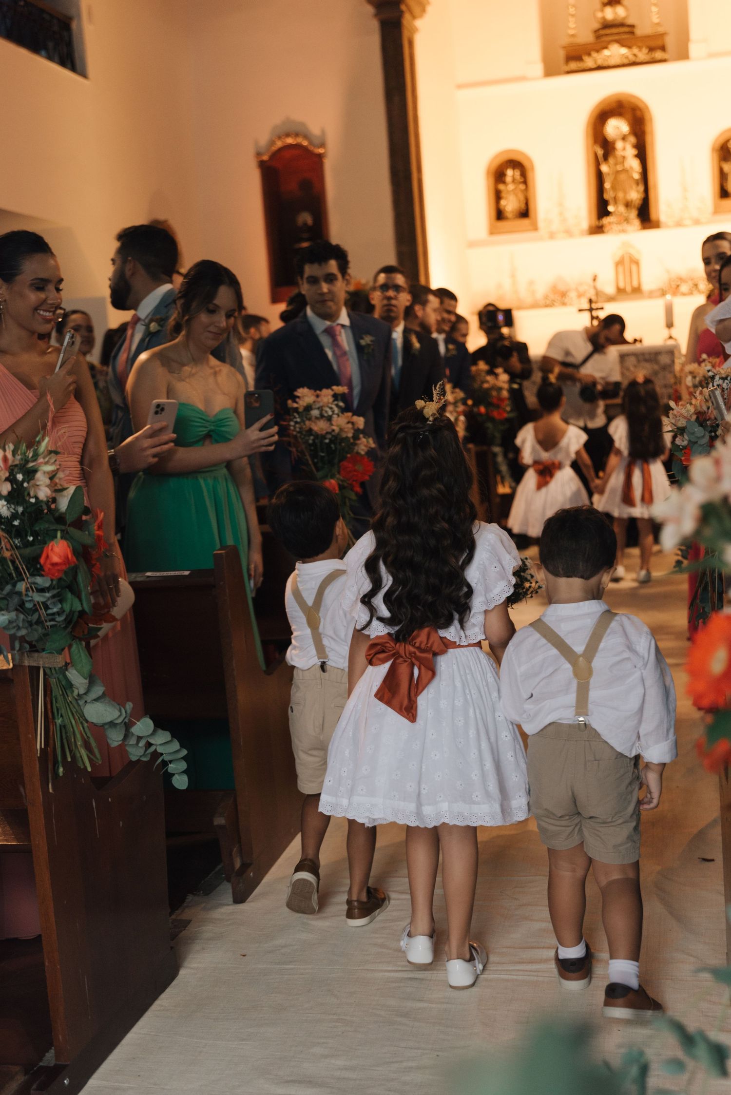 Wedding ceremony in a church with flower girls leading the processional down the aisle.