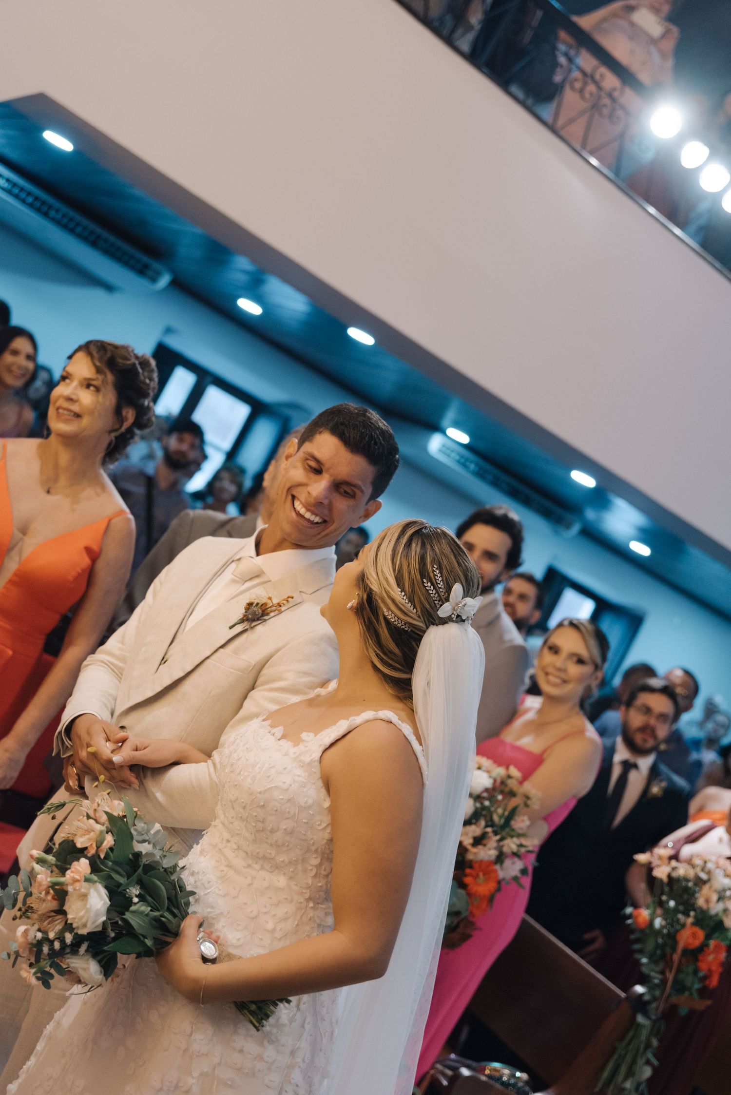 Happy couple enjoying a lighthearted moment during their wedding ceremony in a church.