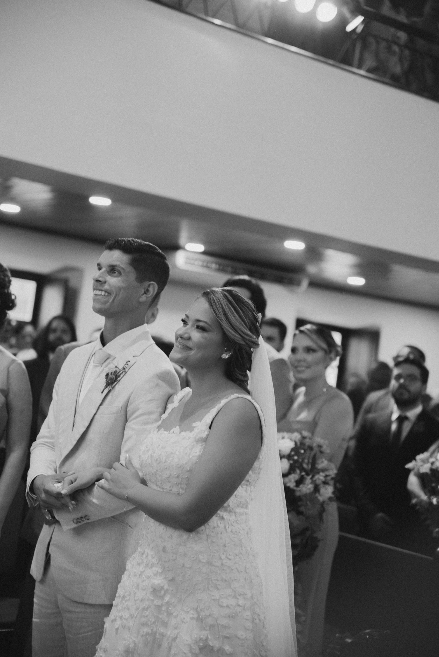 Black and white photo of bride and groom standing together during wedding ceremony.