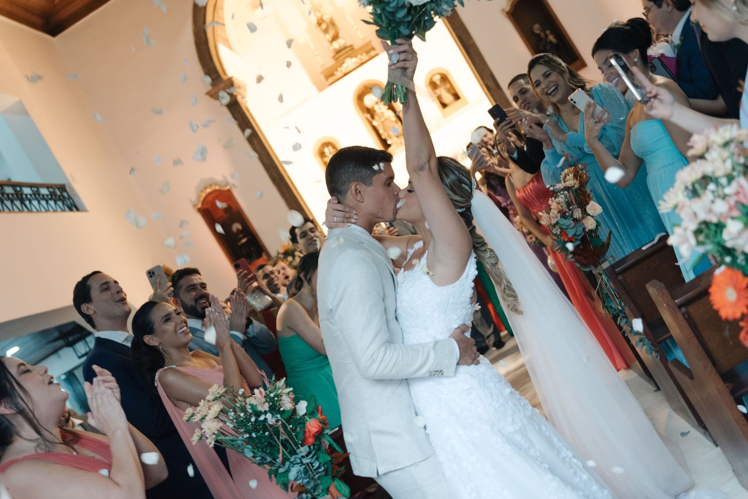 Newlyweds share their first dance surrounded by guests and turquoise decor.