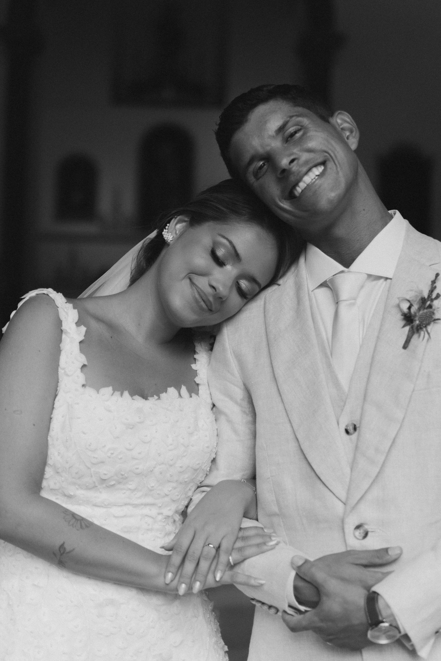 Black and white portrait of a happy couple sharing a tender moment during their wedding ceremony.
