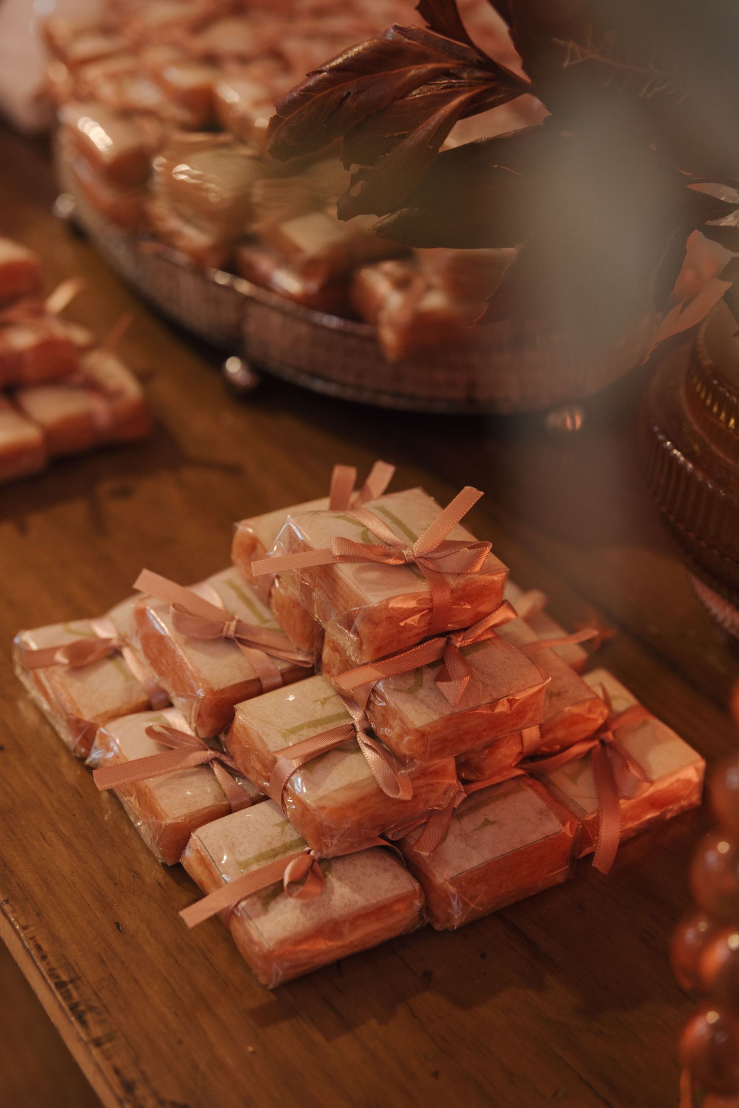 Pink wrapped wedding favors or treats arranged neatly on a wooden surface.