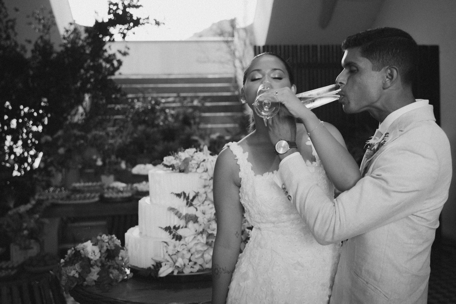 Black and white photo of newlyweds sharing cake during their reception.