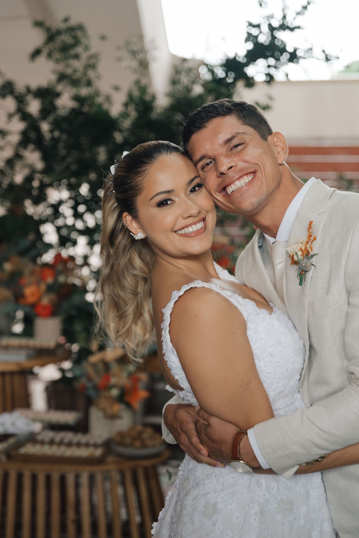 Happy couple in wedding attire sharing a close embrace during their celebration.