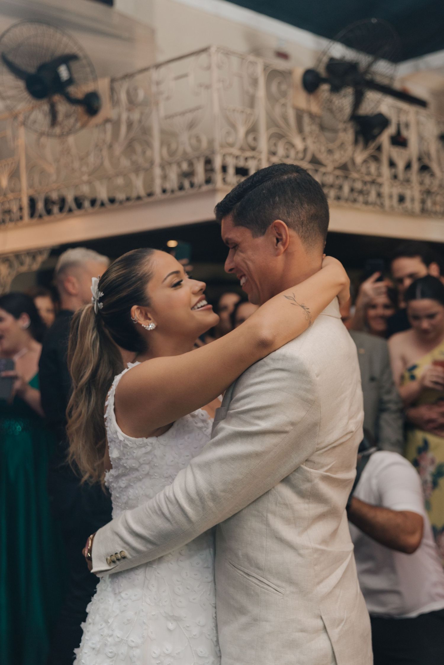 Wedding couple sharing their first dance surrounded by guests at their reception.