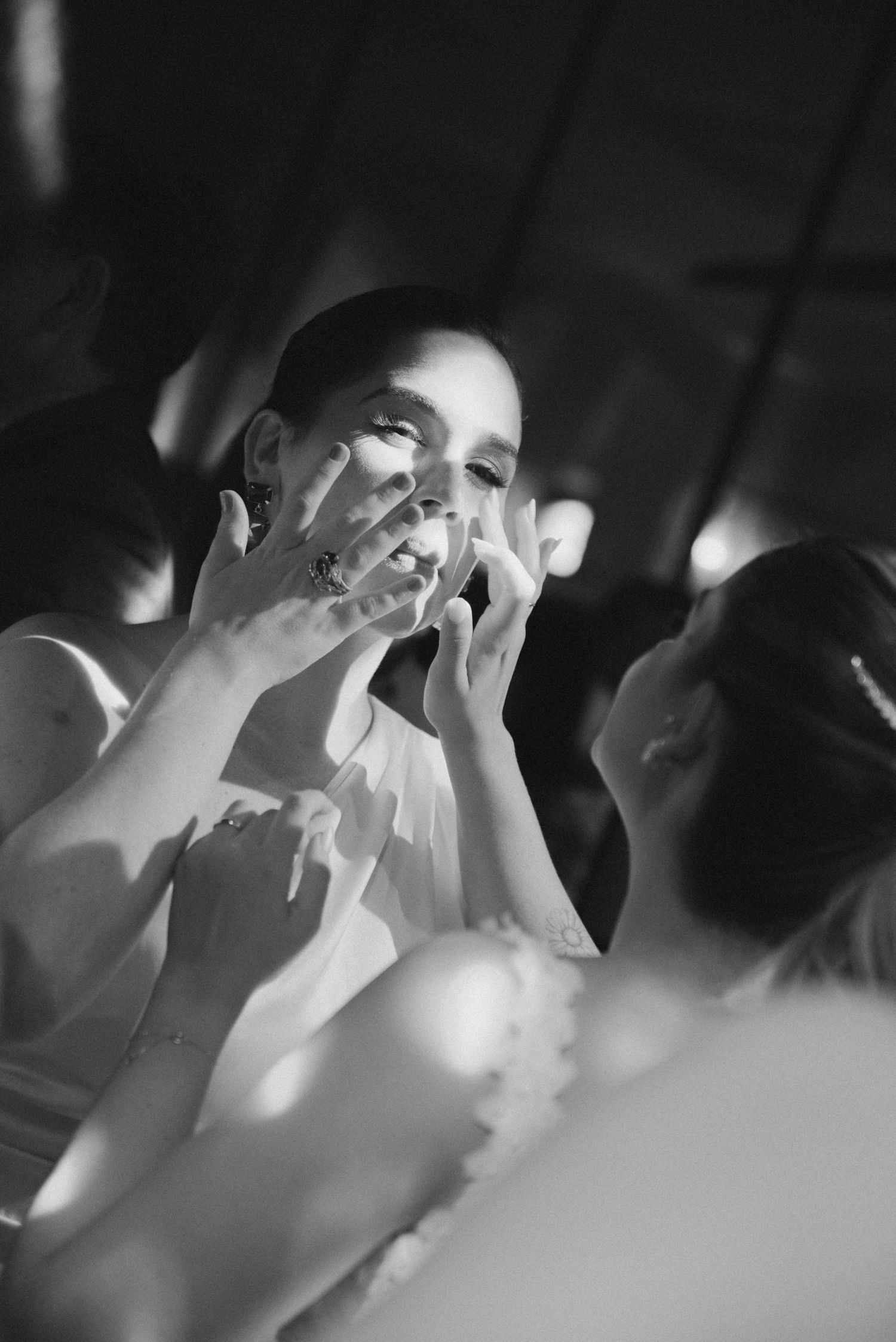 An emotional black and white moment captured during a wedding celebration.