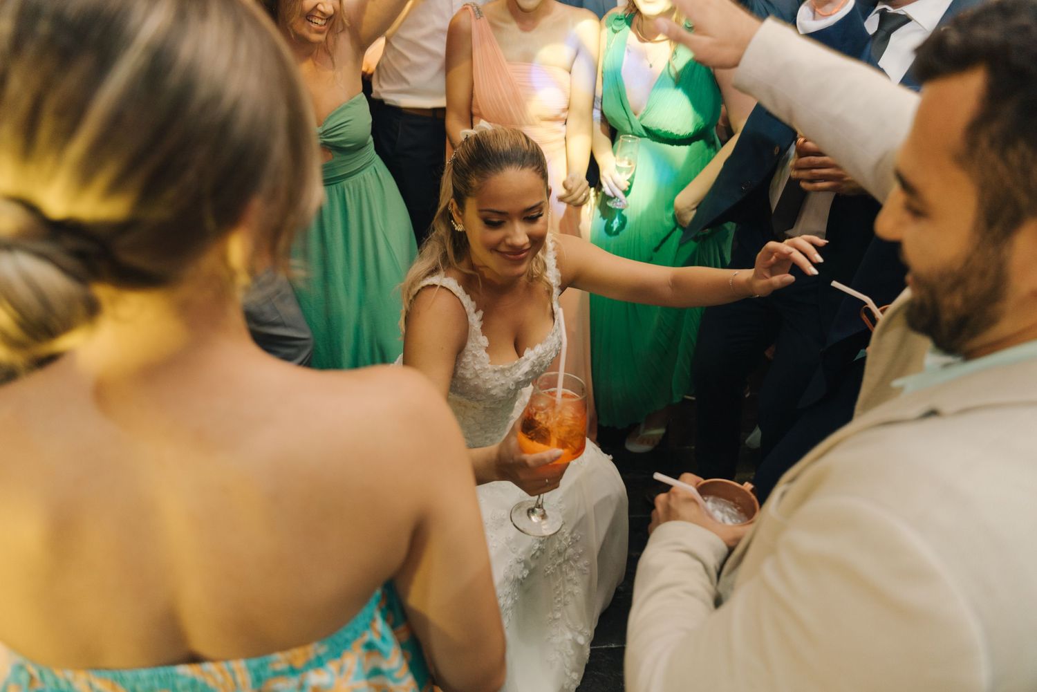 Wedding celebration with guests in colorful attire surrounding the dancing couple.