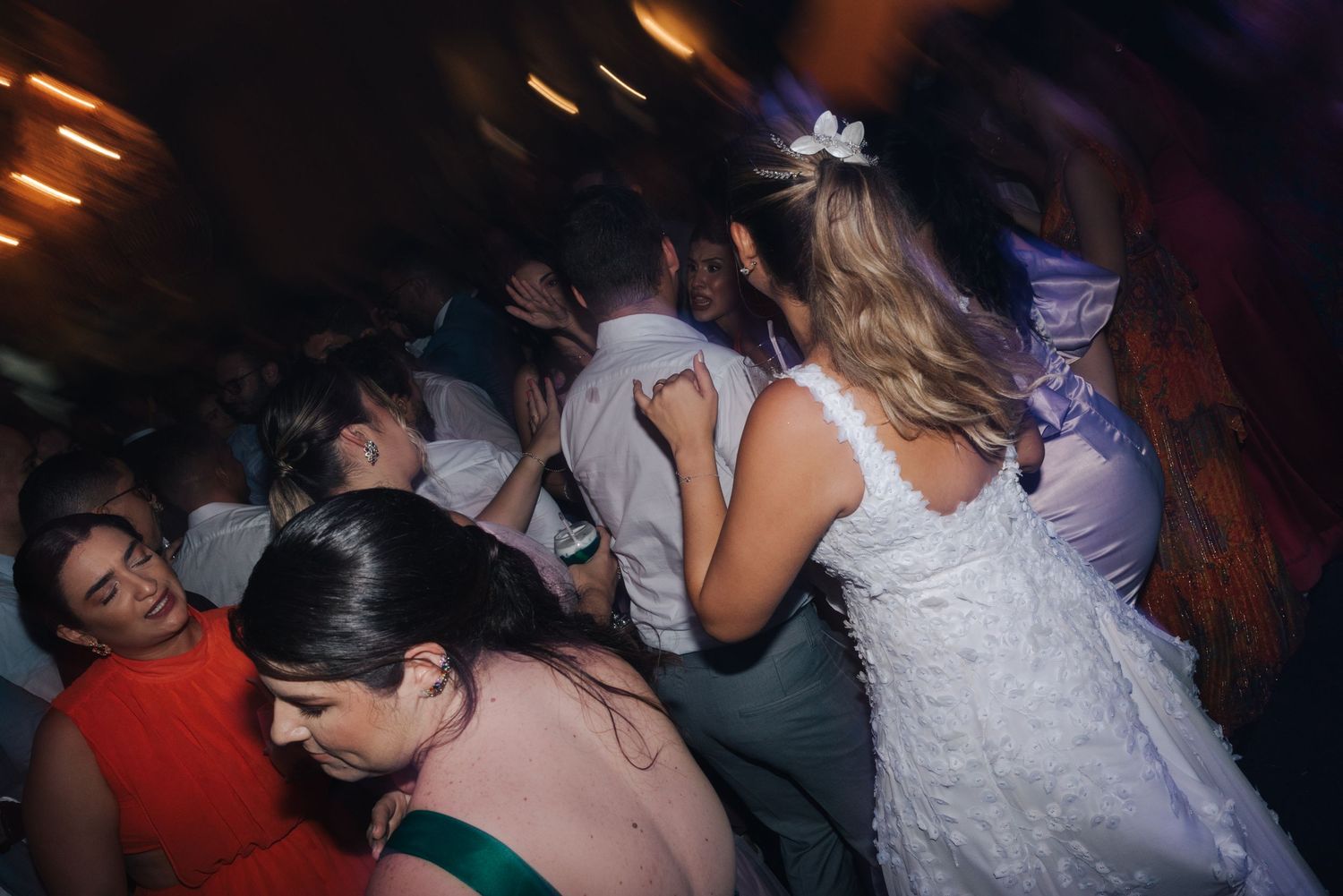 Wedding reception dance floor packed with guests dancing in formal attire.