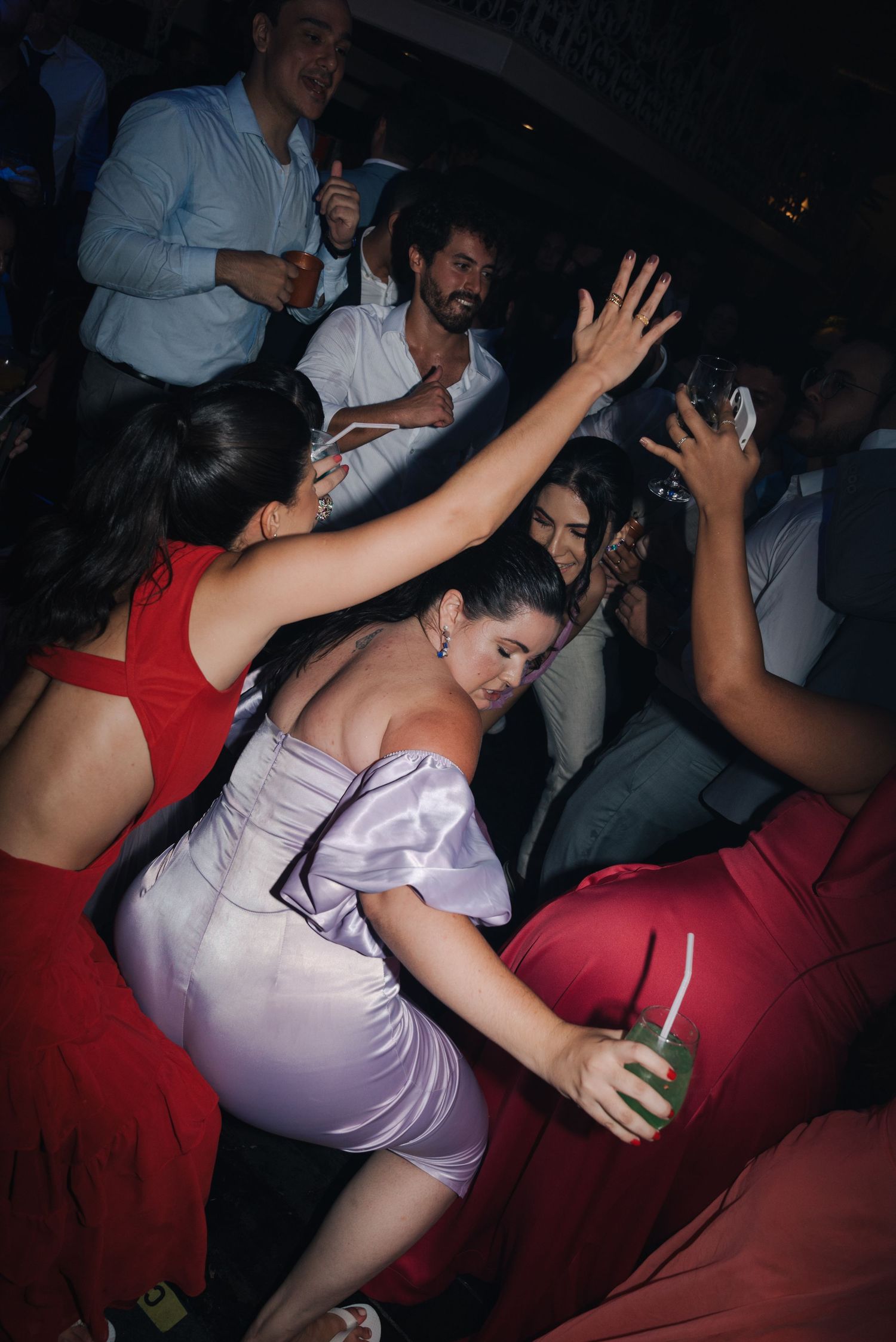 Lively wedding reception with guests dancing and celebrating in formal attire.