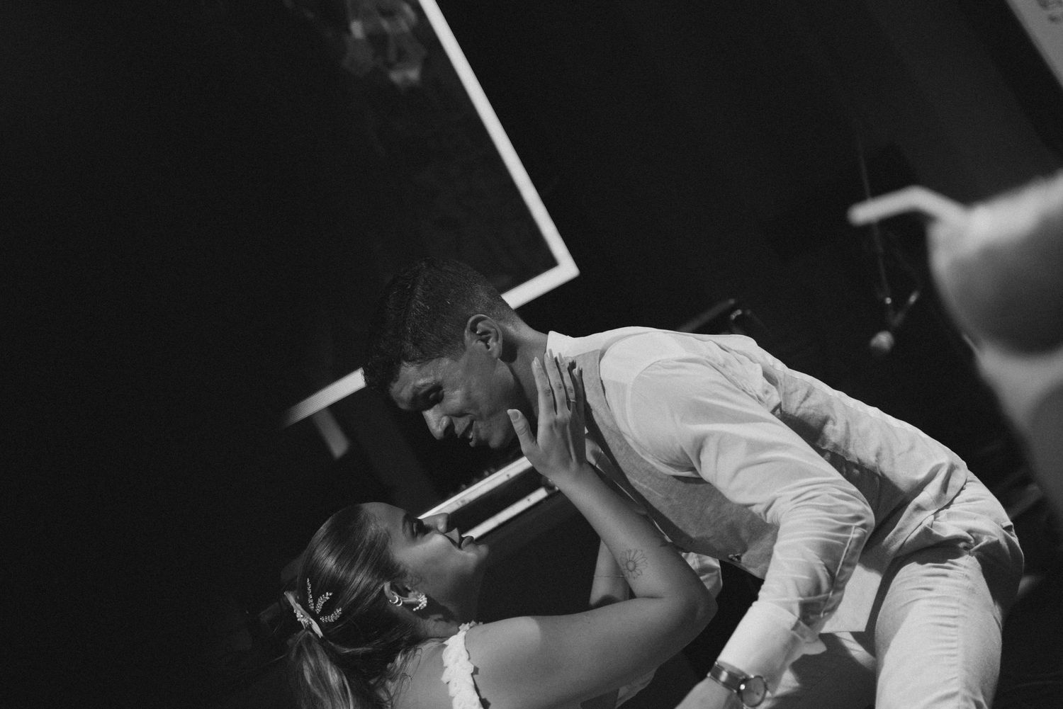 A couple shares an intimate dance moment at their wedding reception in black and white.
