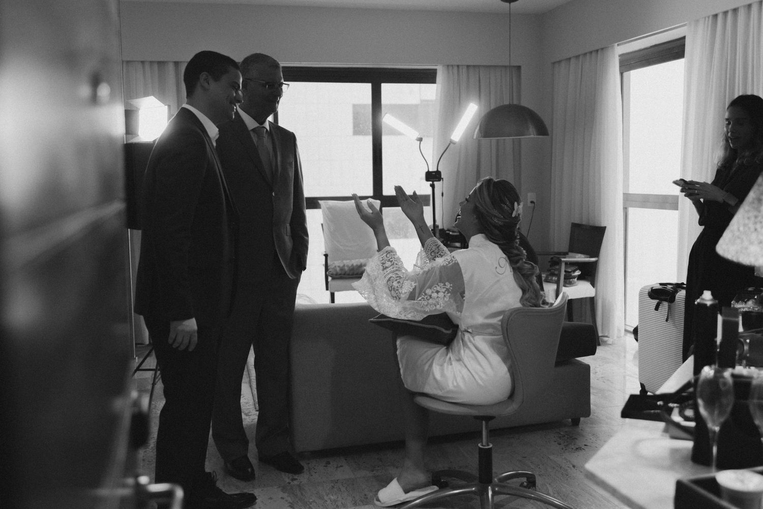 Black and white photo of wedding preparations in hotel room.