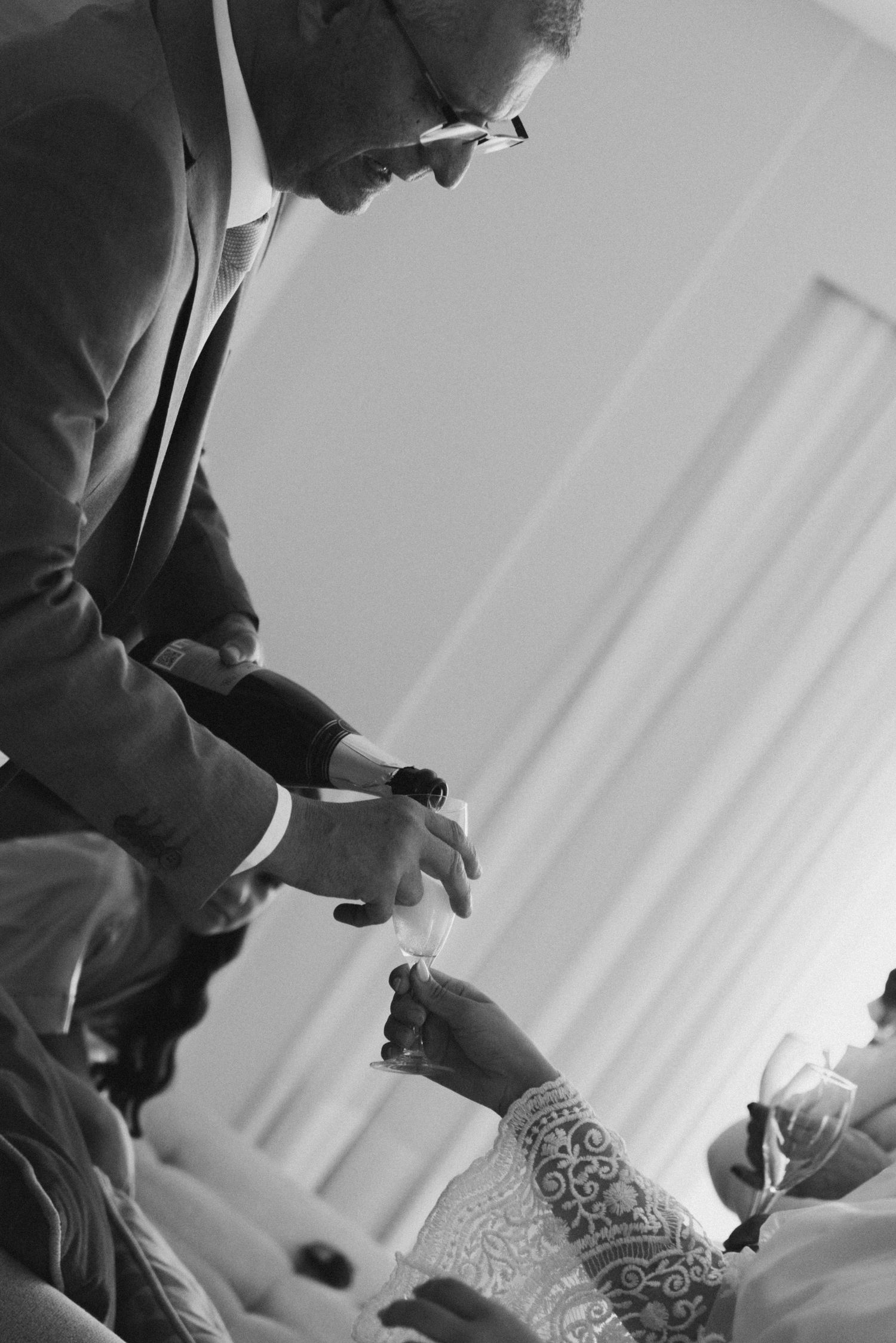 Black and white image of wedding ceremony preparation moment.