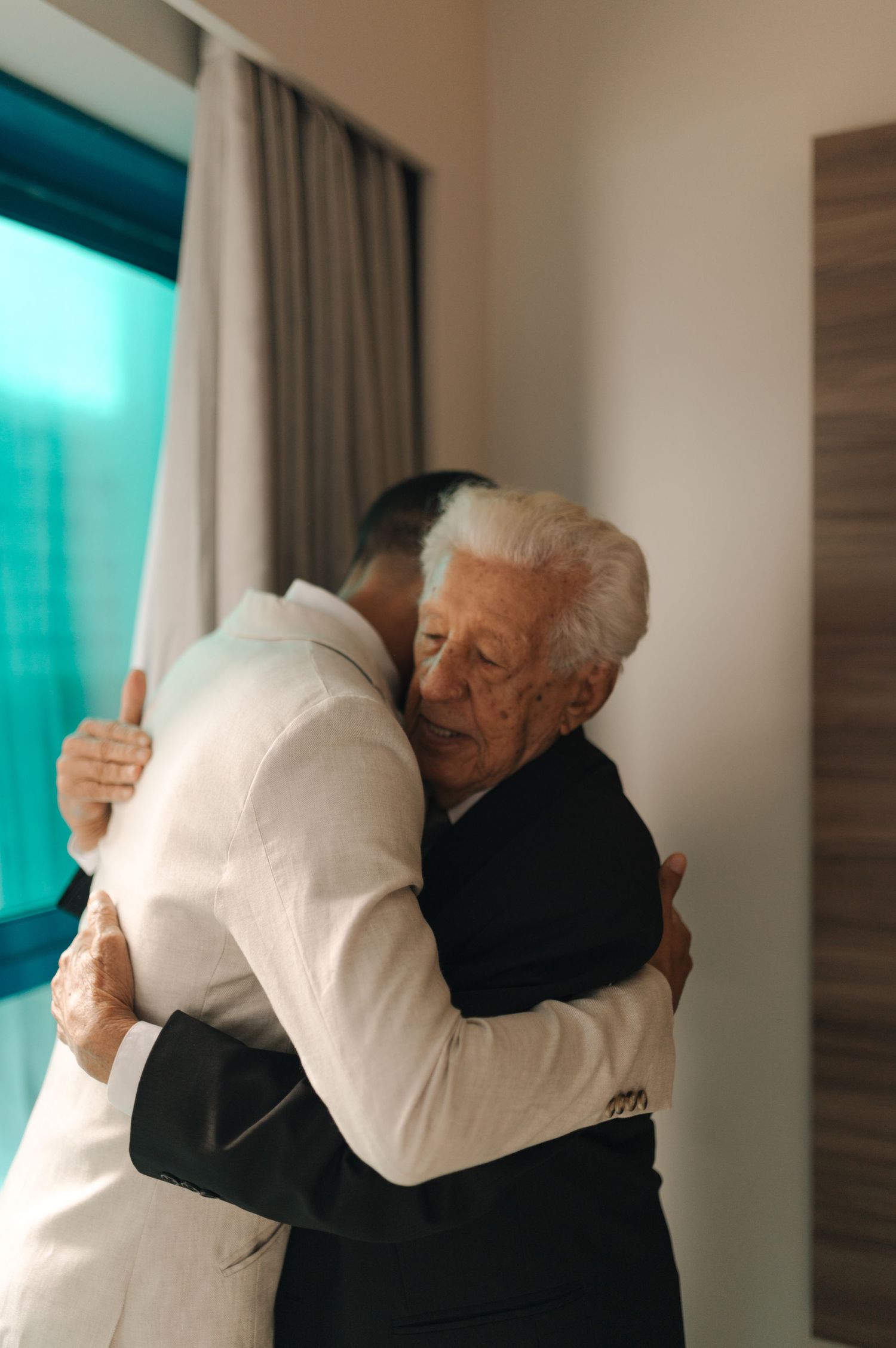 An emotional moment captured as an elderly person in black embraces someone in white.