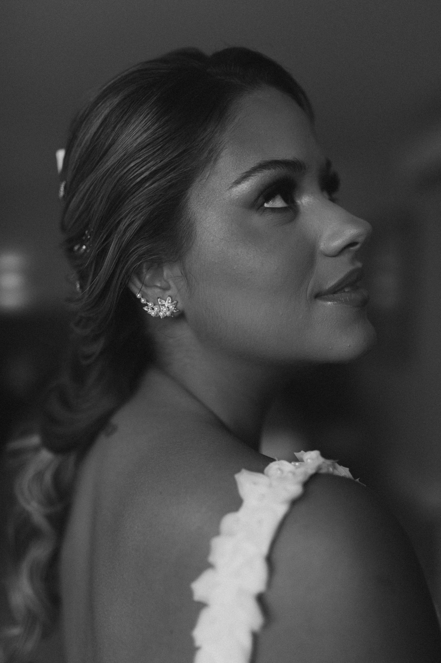 A profile shot of a bride wearing pearl earrings and an elegant updo hairstyle.