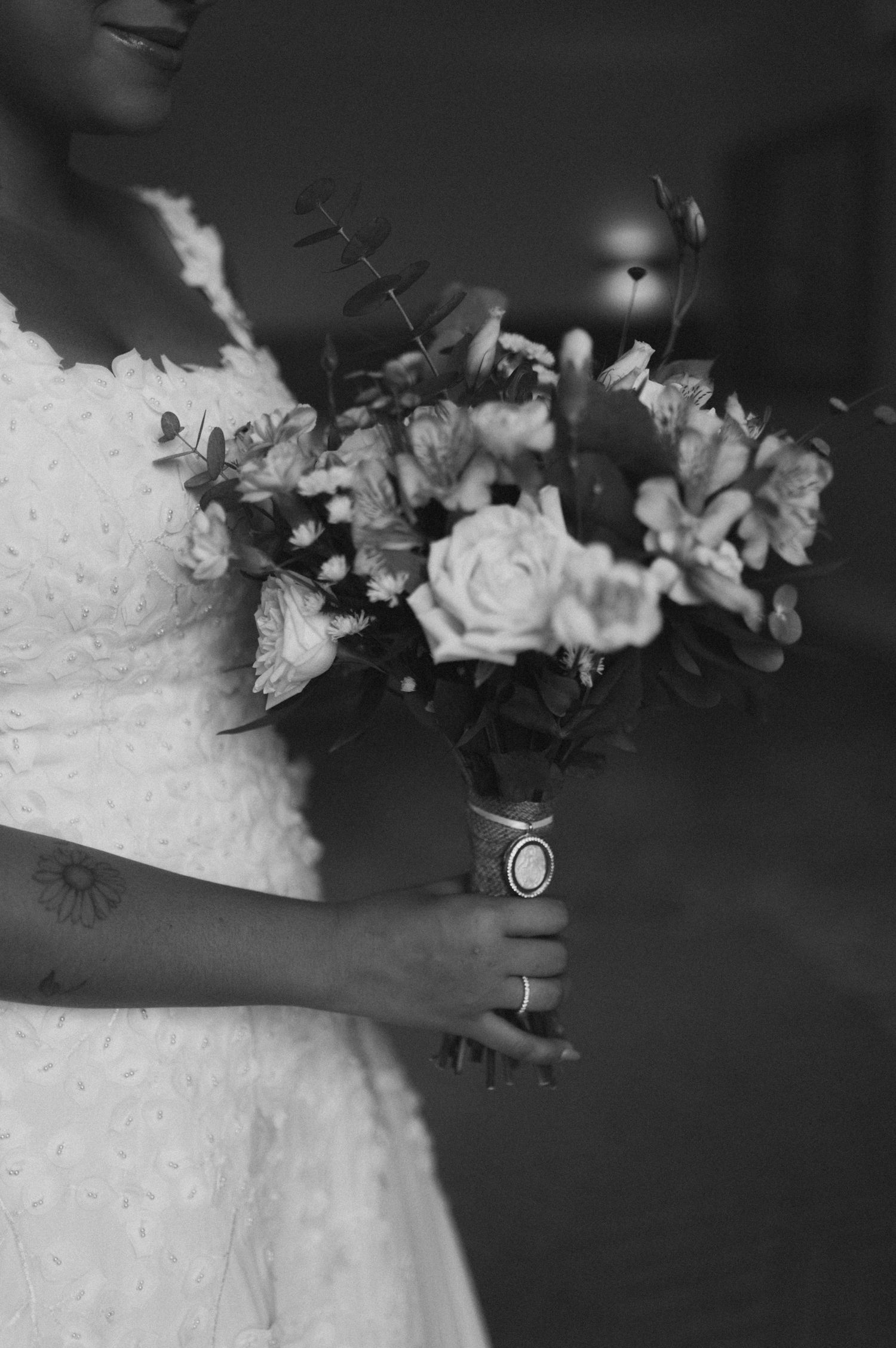 Close-up of bride holding elegant white and pink floral bouquet with roses.