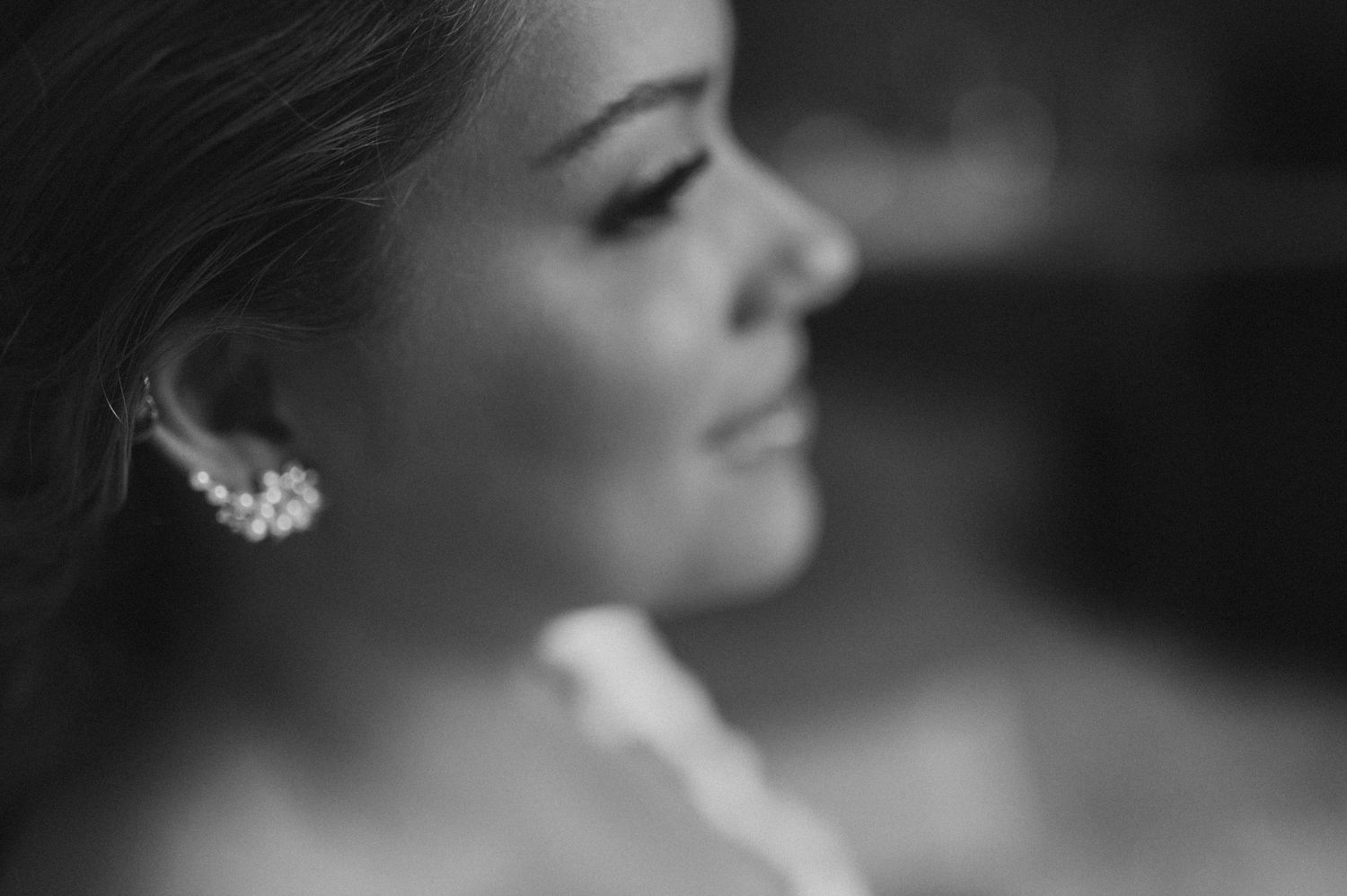 Elegant black and white profile portrait showing bridal jewelry and makeup.