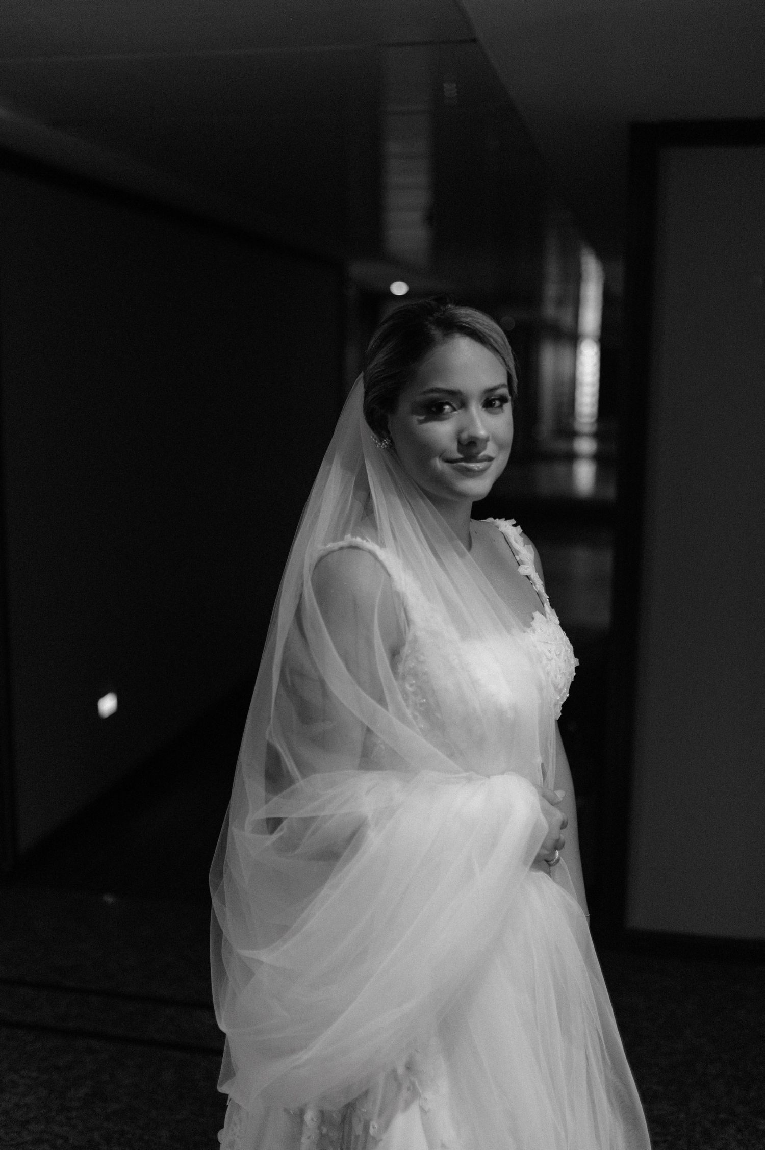 Classic black and white portrait of bride in traditional white gown and veil.