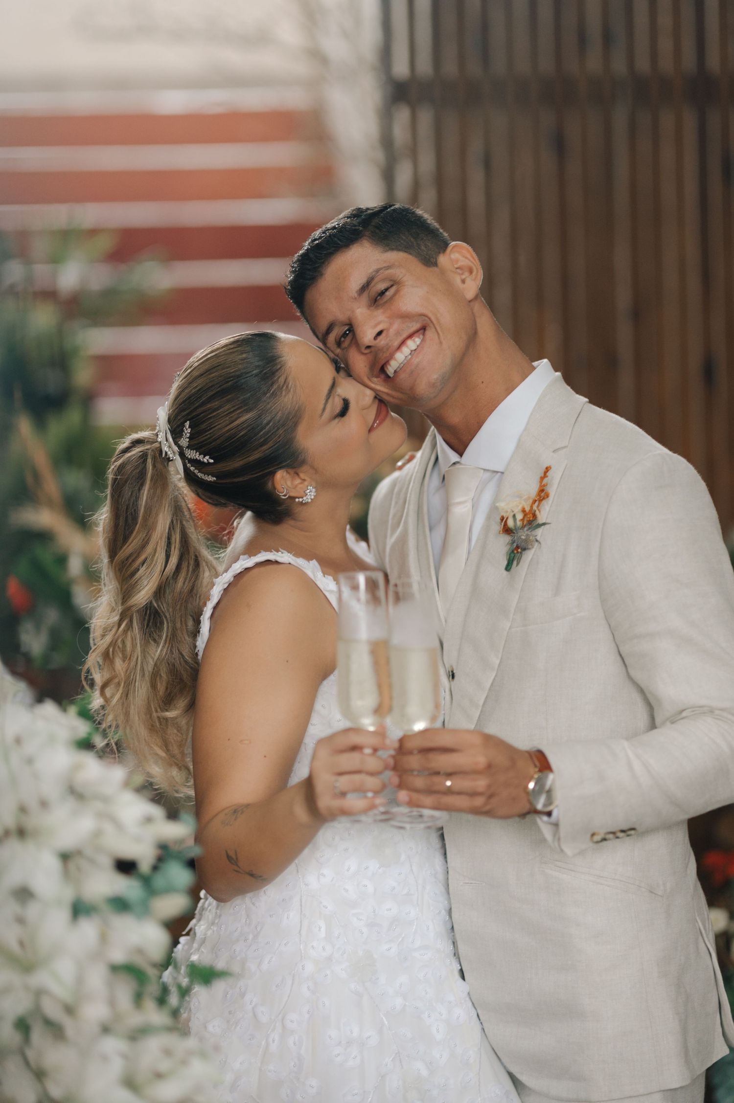 Newlyweds share a champagne toast while embracing during their wedding celebration.